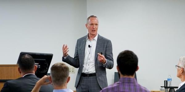 Leeds 教师 member speaking to students and corporate partners at an event