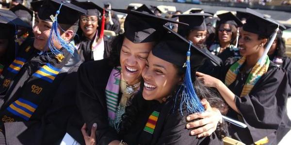 Graduating students hugging each other at commencement