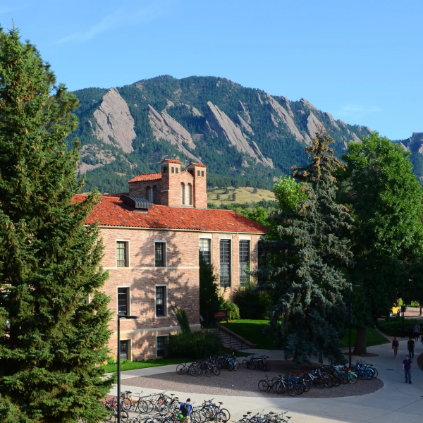 Students walking around campus with the flatirons in the background