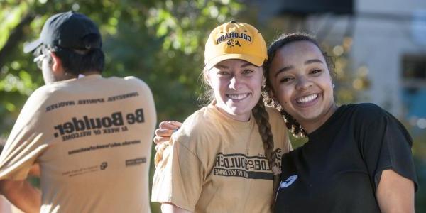 Two friends embrace for a photo at the 2014 Homecoming parade