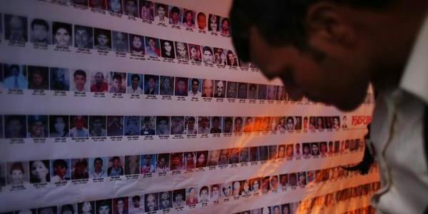 a wall of photos of missing people in Nepal