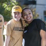 Two friends embrace for a photo at the 2014 Homecoming parade