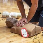 Person practicing CPR on a dummy