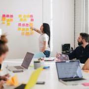 Person putting sticky notes on a wall during a meeting