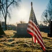 Tiny American flag in ground at cemetery